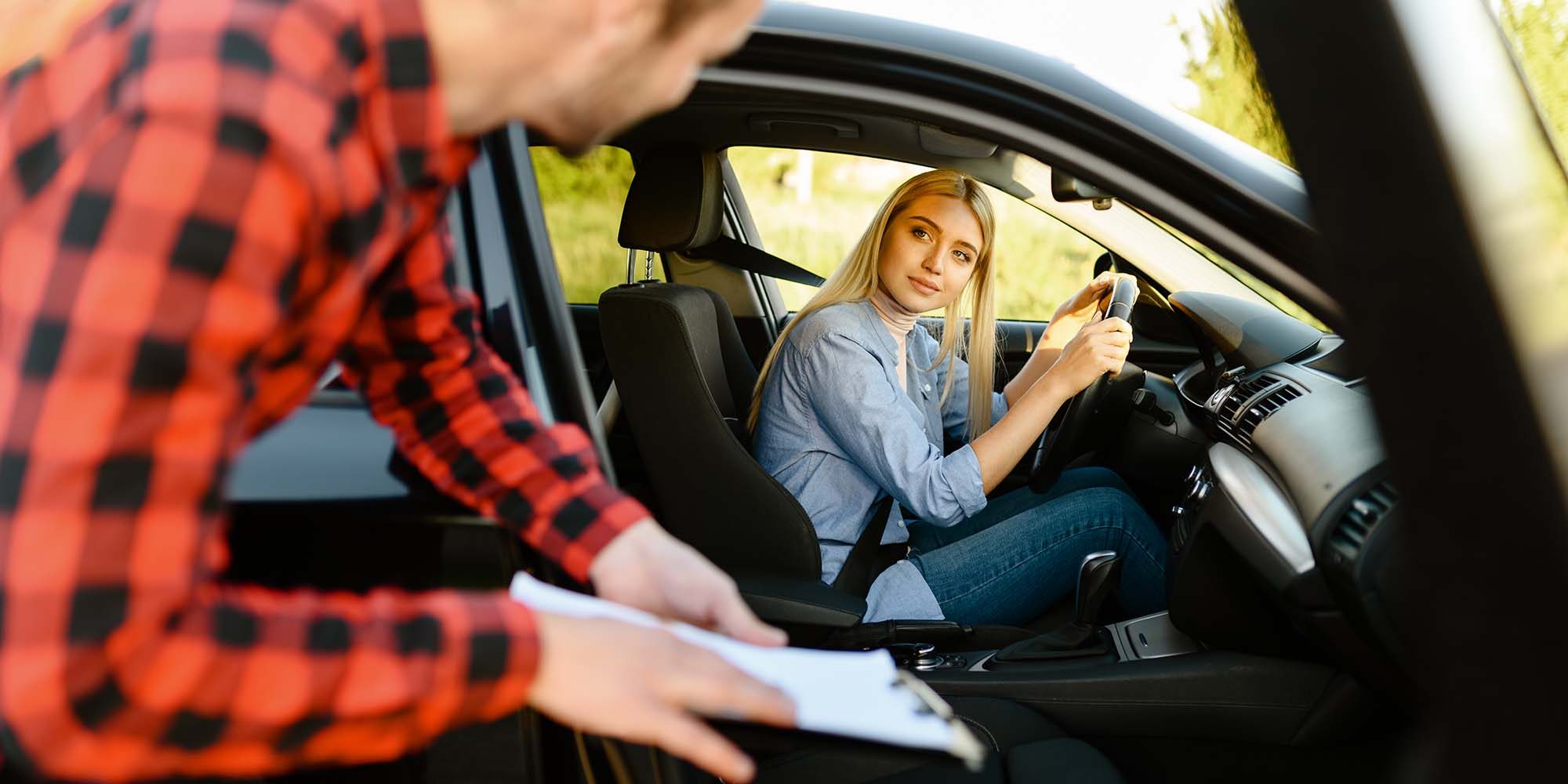 woman-in-car-looks-on-instructor-with-checklist-K8YV5PS.jpg